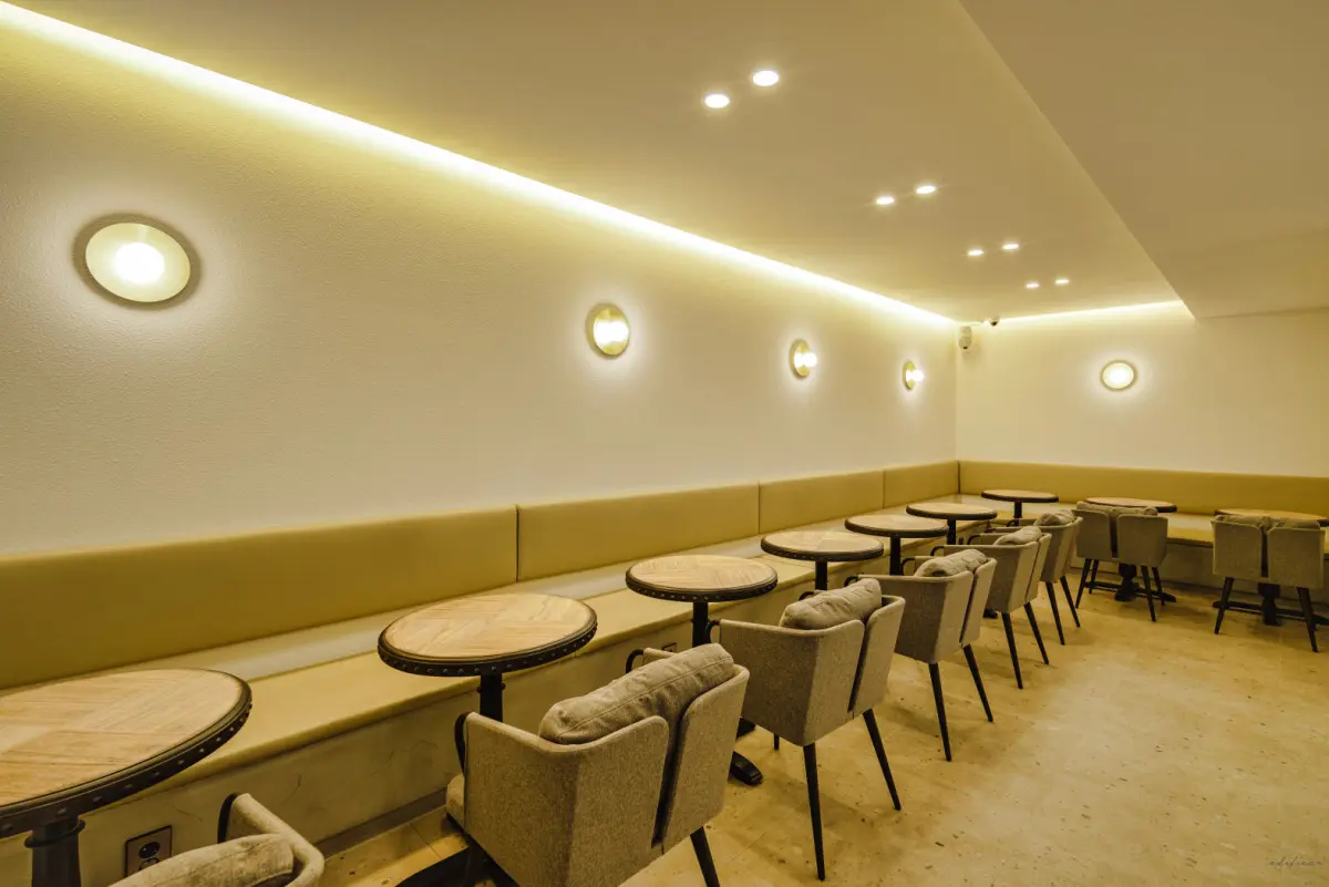 따뜻한 조명과 붙박이 좌석의 아늑한 카페 공간